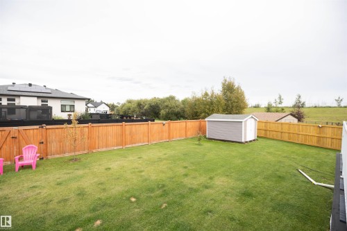 Expansive fenced yard featuring a storage shed and a lush lawn - 6003 50 Ave, Barrhead, AB 