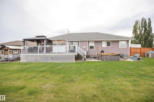 Expansive backyard with a large deck, white railings, and a gazebo - 6003 50 Ave, Barrhead, AB 