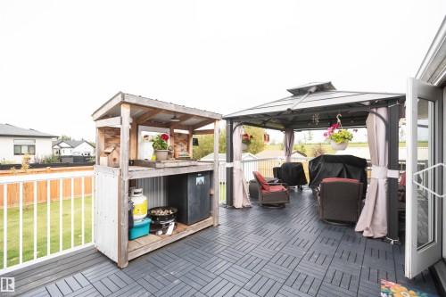 Deck featuring modular dark gray flooring and a white railing - 6003 50 Ave, Barrhead, AB 