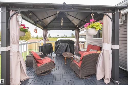 Covered deck with a slatted floor and grey siding - 6003 50 Ave, Barrhead, AB 