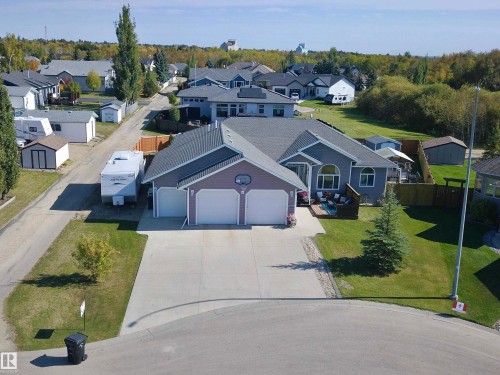 Single-story residence with a two-car garage, concrete driveway, and a fenced backyard - 6003 50 Ave, Barrhead, AB 