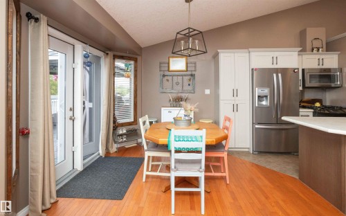 Vaulted ceiling with a contemporary open-frame chandelier - 6003 50 Ave, Barrhead, AB 