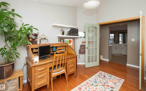 Hardwood-finish flooring, light grey wall paint, and a door with frosted glass panels - 6003 50 Ave, Barrhead, AB 