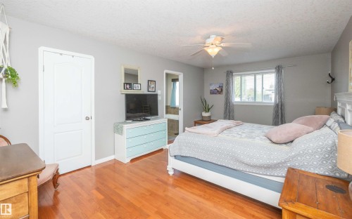 Hardwood flooring, ceiling fan with integrated lighting, white paneled interior door, and a window with blinds - 6003 50 Ave, Barrhead, AB 