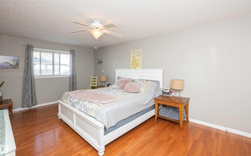 Hardwood flooring, painted walls, white trim, window with blinds, and a ceiling fan with integrated lighting - 6003 50 Ave, Barrhead, AB 