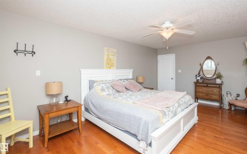 Wood-finish flooring throughout, light gray wall finishes, and a ceiling fan with integrated lighting - 6003 50 Ave, Barrhead, AB 