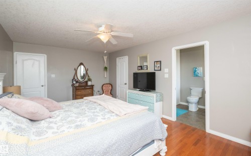 Hardwood-finish flooring with light-toned wall paint and an attached ceiling fan - 6003 50 Ave, Barrhead, AB 