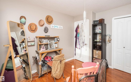 Hardwood-finish flooring, light neutral wall paint, white trim, white paneled doors, and a ceiling-mounted light fixture - 6003 50 Ave, Barrhead, AB 