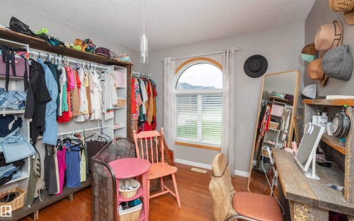 Wood-finish flooring, built-in shelving, arched window, and overhead lighting fixture - 6003 50 Ave, Barrhead, AB 