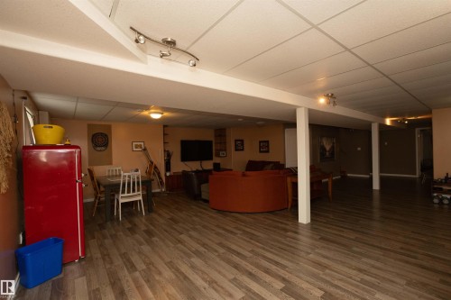 Expansive open-concept room featuring wood-finish flooring, drop ceiling, and recessed lighting - 6003 50 Ave, Barrhead, AB 