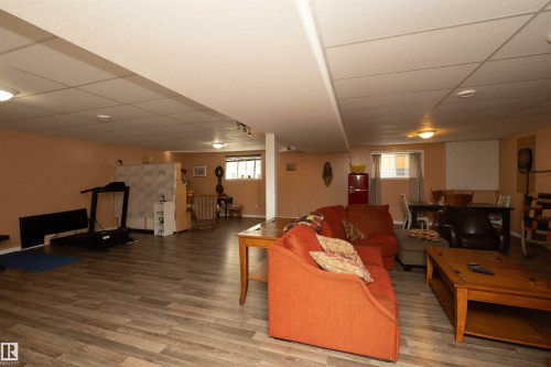 Wood-finish flooring throughout, ceiling-mounted lighting, and a drop ceiling - 6003 50 Ave, Barrhead, AB 
