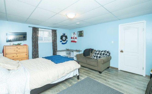 Recessed ceiling, light blue painted walls, wood-finish flooring, single window, white interior door - 6003 50 Ave, Barrhead, AB 