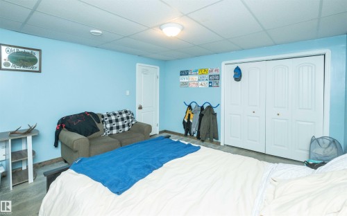 Recessed lighting, drop ceiling, bi-fold closet doors, and wood-finish flooring - 6003 50 Ave, Barrhead, AB 