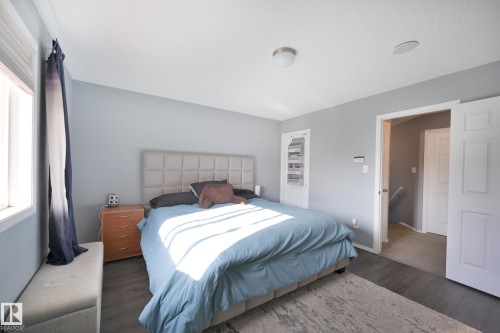 Wood-finish flooring with a ceiling-mounted light fixture - 8127 7 Avenue Sw, Edmonton, AB 