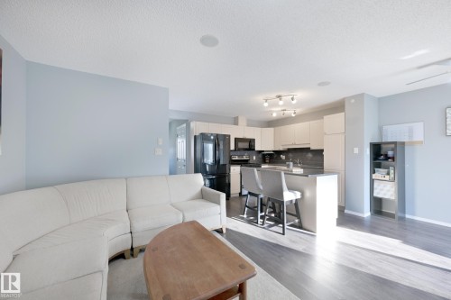 Open concept living area with wood-finish flooring - 8127 7 Avenue Sw, Edmonton, AB 