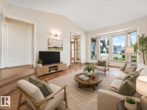 Spacious living area featuring large bay windows, wood-finish flooring, and recessed ceiling details - 8008 158 Avenue Nw, Edmonton, AB - Indoor Photo Showing Living Room