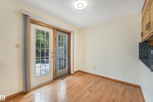 Room with wood-finish flooring and cream-colored walls - 8008 158 Avenue Nw, Edmonton, AB - Indoor Photo Showing Other Room