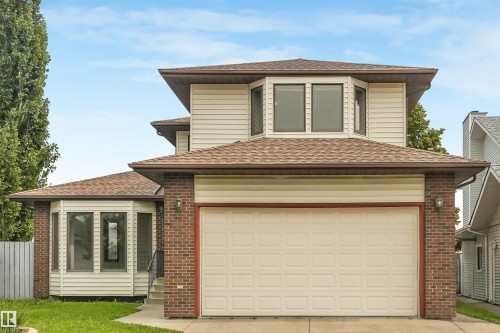 Traditional two-story residence featuring brick and siding exterior, an attached two-car garage, and a bay window on the first level - 8008 158 Avenue Nw, Edmonton, AB - Outdoor