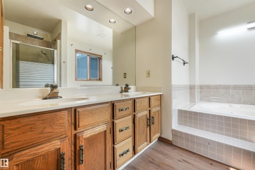 Dual vanity with integrated sinks and wood-finish cabinetry - 8008 158 Avenue Nw, Edmonton, AB - Indoor Photo Showing Bathroom