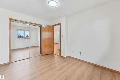 Room featuring wood-finish flooring, white walls, and a ceiling-mounted light fixture - 8008 158 Avenue Nw, Edmonton, AB - Indoor Photo Showing Other Room