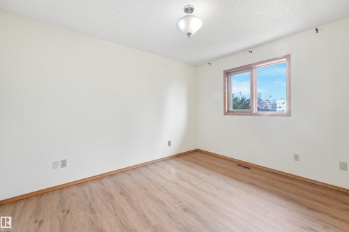 Room with wood-finish flooring, white walls, and a wood-framed window - 8008 158 Avenue Nw, Edmonton, AB - Indoor Photo Showing Other Room