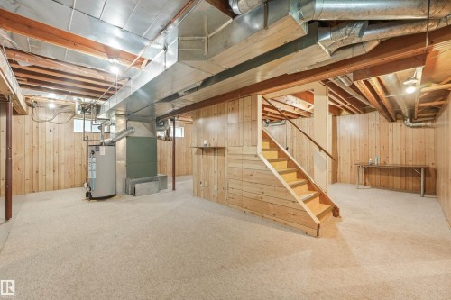 Spacious basement with light-toned carpeting and wood paneling throughout - 8008 158 Avenue Nw, Edmonton, AB - Indoor Photo Showing Basement