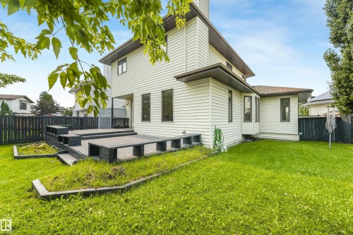 Multi-level composite deck with integrated planters and seating, surrounded by a fenced backyard - 8008 158 Avenue Nw, Edmonton, AB - Outdoor