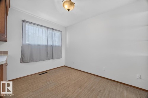 Wood-finish flooring with white walls and a single window - 6104 92 Avenue Nw, Edmonton, AB 