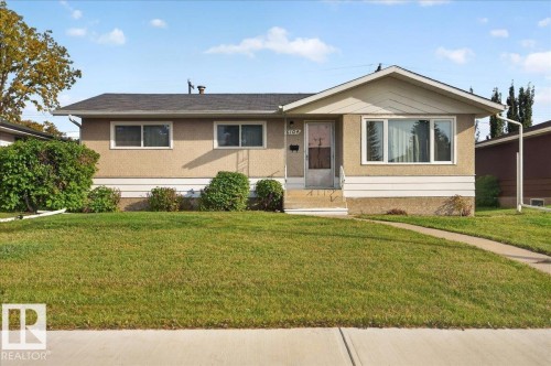 Stucco exterior with a gable roofline, large picture window, and covered entry - 6104 92 Avenue Nw, Edmonton, AB 
