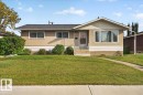 Stucco exterior with a gable roofline, large picture window, and covered entry - 6104 92 Avenue Nw, Edmonton, AB 