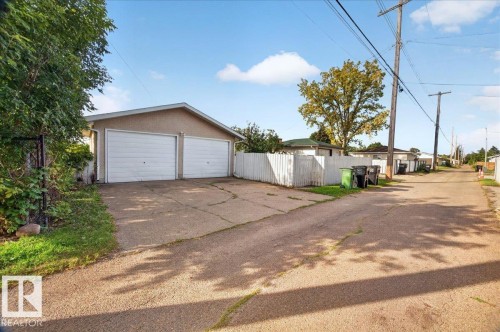 Detached two-car garage with white garage doors and a concrete driveway - 6104 92 Avenue Nw, Edmonton, AB 