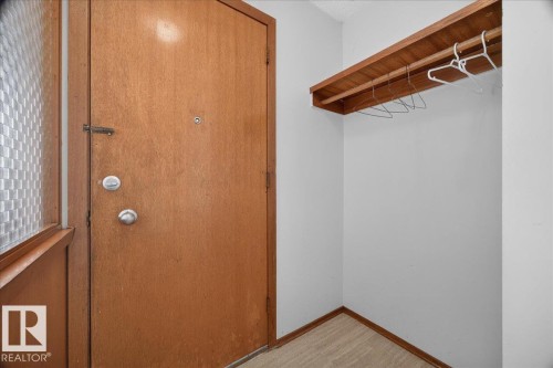 Wood-finish entry door with modern silver-tone hardware - 6104 92 Avenue Nw, Edmonton, AB 