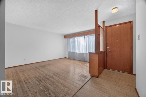 Wood-finish flooring, white walls, built-in room divider, wood door, and recessed lighting - 6104 92 Avenue Nw, Edmonton, AB 