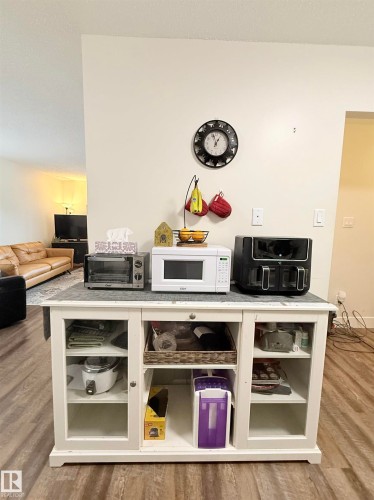 White storage cabinet with glass-front doors, open shelving, and a solid top surface - #89 2703 79 St Nw, Edmonton, AB 