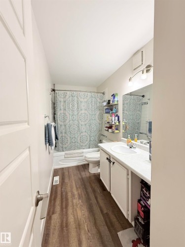 Wood-finish flooring with a white vanity featuring a basin sink - #89 2703 79 St Nw, Edmonton, AB 