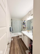 Wood-finish flooring with a white vanity featuring a basin sink - 
