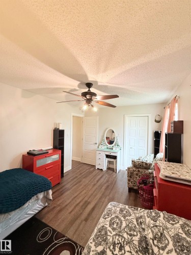 Wood-finish flooring throughout, ceiling fan with integrated lighting, and multiple paneled doors - #89 2703 79 St Nw, Edmonton, AB 