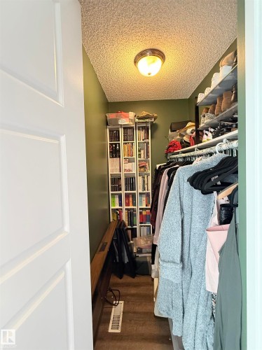 Walk-in closet with built-in shelving, hanging rods, and an overhead light fixture - #89 2703 79 St Nw, Edmonton, AB 
