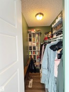 Walk-in closet with built-in shelving, hanging rods, and an overhead light fixture - 