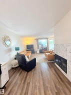 Wood-finish flooring, white walls, and a tiled fireplace - 
