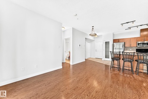 Hardwood-finish flooring extending into the main living space - #307 1003 Gault Bv Nw, Edmonton, AB - Indoor Photo Showing Kitchen