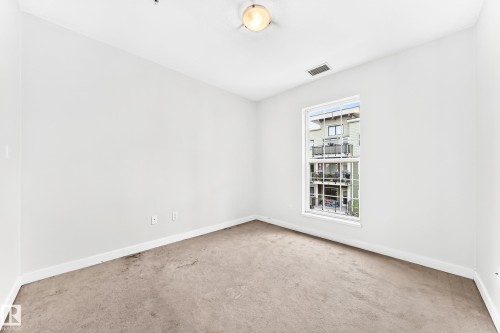 Carpeted room featuring a single window and a ceiling-mounted light fixture - #307 1003 Gault Bv Nw, Edmonton, AB - Indoor Photo Showing Other Room