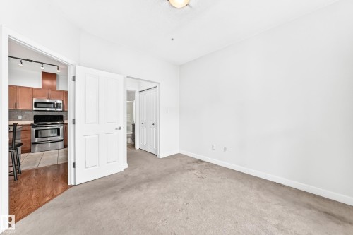 Bright living space with neutral wall tones and carpeted flooring - #307 1003 Gault Bv Nw, Edmonton, AB - Indoor Photo Showing Other Room