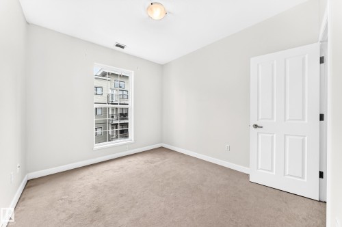 Room featuring neutral wall paint, light brown carpeting, and white trim - #307 1003 Gault Bv Nw, Edmonton, AB - Indoor Photo Showing Other Room
