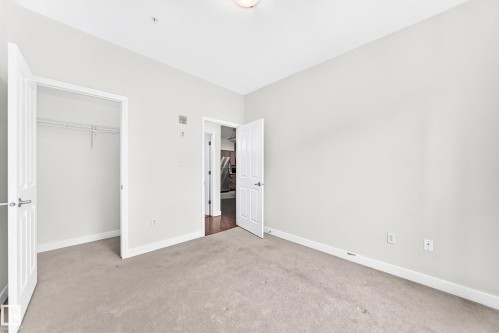 Carpeted interior space with light gray walls, white trim, and a ceiling-mounted light fixture - #307 1003 Gault Bv Nw, Edmonton, AB - Indoor Photo Showing Other Room