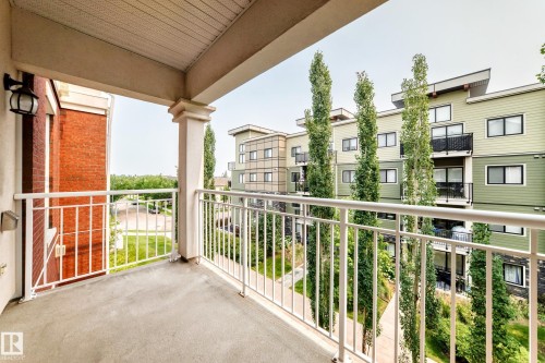 Private balcony with a concrete surface and white metal railings - #307 1003 Gault Bv Nw, Edmonton, AB - Outdoor With Balcony With Exterior
