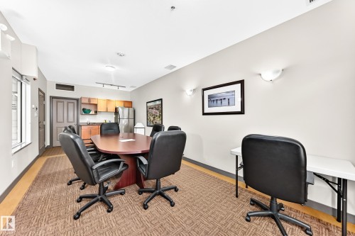 Conference room featuring a wood-finish table, patterned carpet, and built-in kitchenette - #307 1003 Gault Bv Nw, Edmonton, AB - Indoor Photo Showing Office