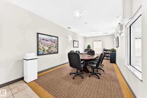 Spacious meeting room featuring extensive wall space, large windows, recessed and sconce lighting, and durable patterned carpeting - #307 1003 Gault Bv Nw, Edmonton, AB - Indoor