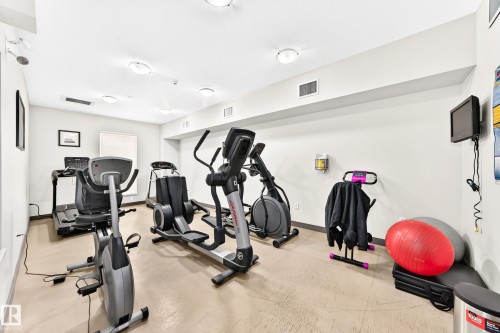 Fitness room with multiple exercise machines, recessed lighting, and light-toned flooring - #307 1003 Gault Bv Nw, Edmonton, AB - Indoor Photo Showing Gym Room