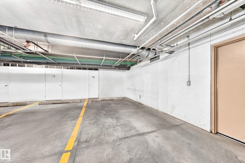 Concrete parking area with painted yellow space markers - #307 1003 Gault Bv Nw, Edmonton, AB - Indoor Photo Showing Garage